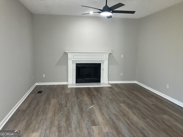 unfurnished living room featuring a tiled fireplace, ceiling fan, dark hardwood / wood-style flooring, and a textured ceiling