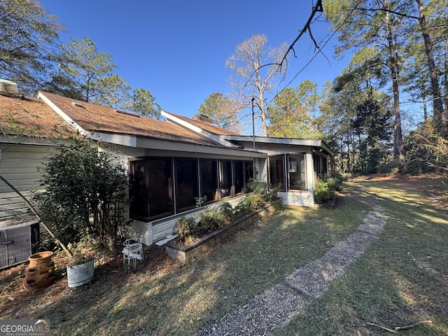 back of house with a sunroom and a yard