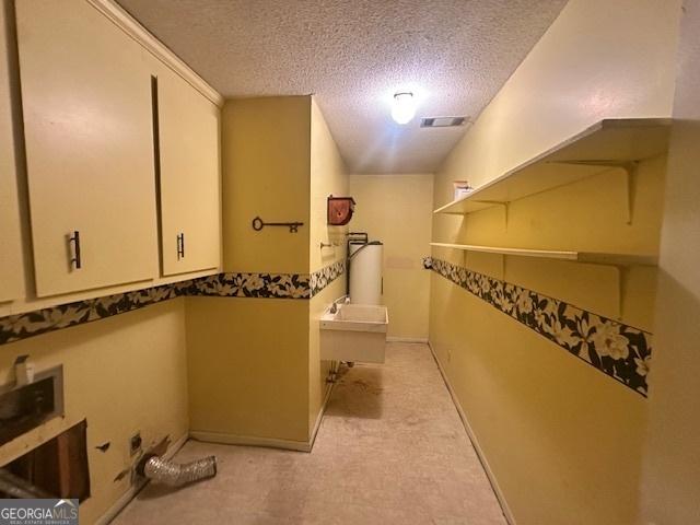 interior space with baseboards, visible vents, a tub, a textured ceiling, and a sink