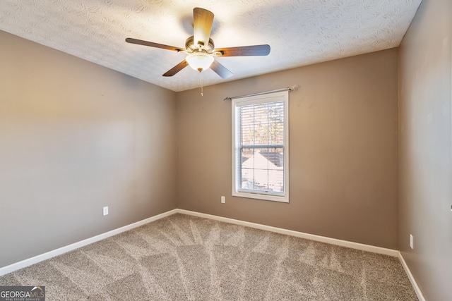 spare room featuring a textured ceiling, carpet floors, and ceiling fan