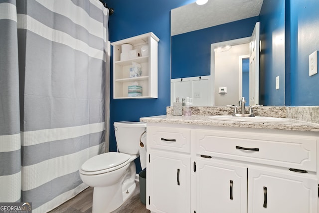 bathroom featuring wood-type flooring, vanity, and toilet