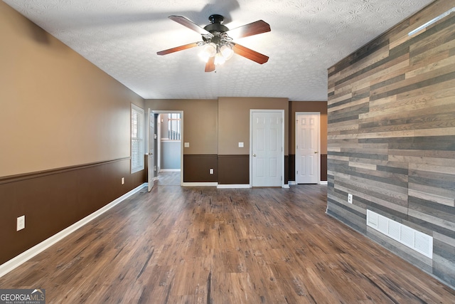 spare room featuring ceiling fan, dark hardwood / wood-style flooring, and a textured ceiling