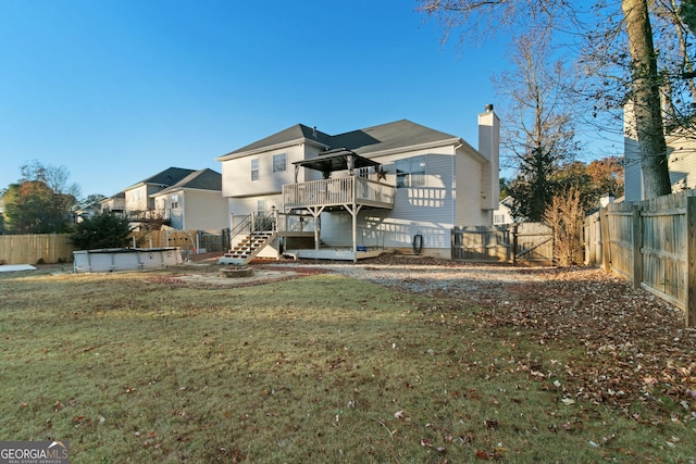 back of house featuring a swimming pool side deck and a yard