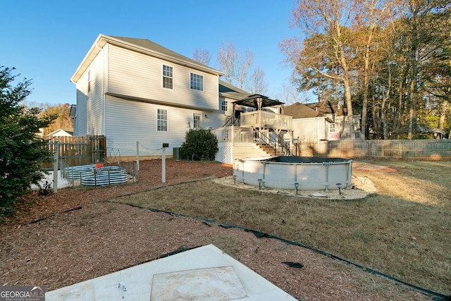 back of house featuring a yard and a covered pool