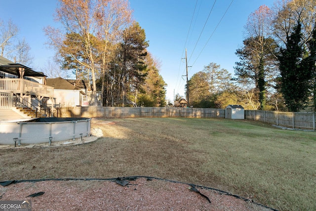 view of yard featuring a storage shed and a pool side deck