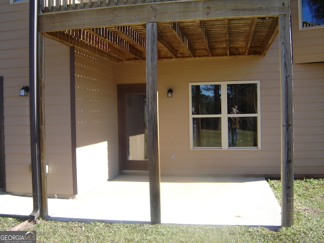 doorway to property featuring a wooden deck and a patio