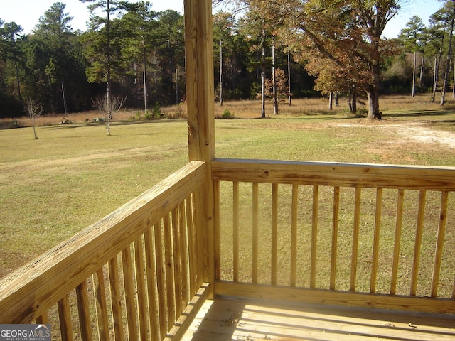 wooden terrace featuring a lawn