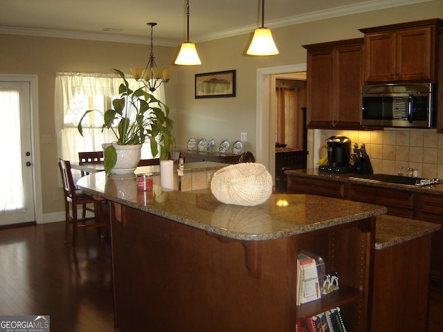 kitchen featuring decorative light fixtures, dark hardwood / wood-style floors, decorative backsplash, and crown molding