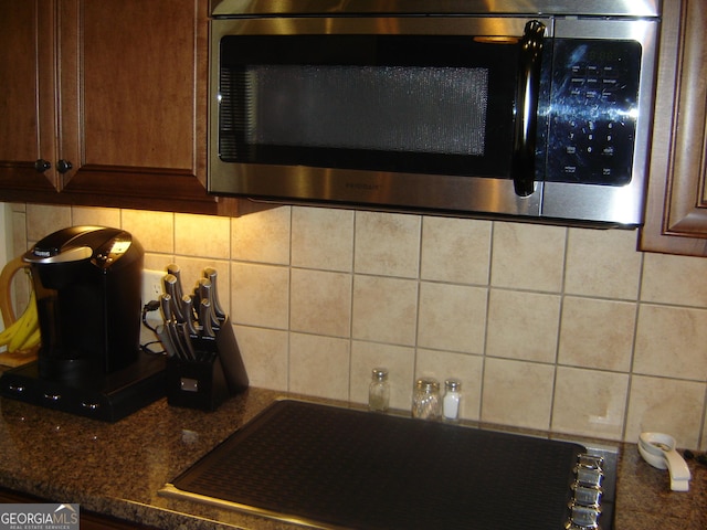 details with backsplash, sink, and dark stone counters