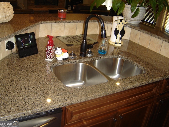 room details featuring stainless steel dishwasher, backsplash, and sink