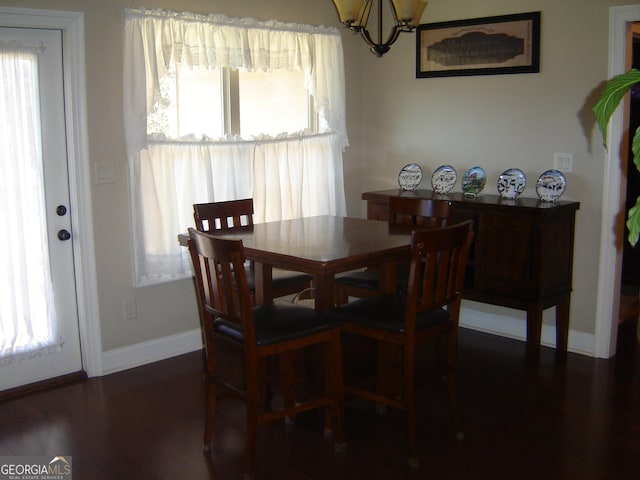 dining room with a wealth of natural light, dark hardwood / wood-style flooring, and a notable chandelier