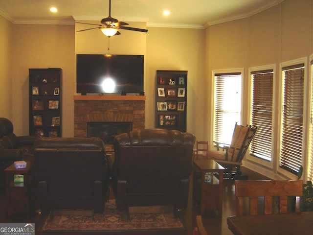 living room with a stone fireplace, ceiling fan, and ornamental molding