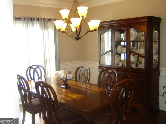 dining room with wood-type flooring, crown molding, and a notable chandelier