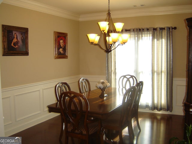 dining room with dark wood-type flooring, a notable chandelier, and ornamental molding