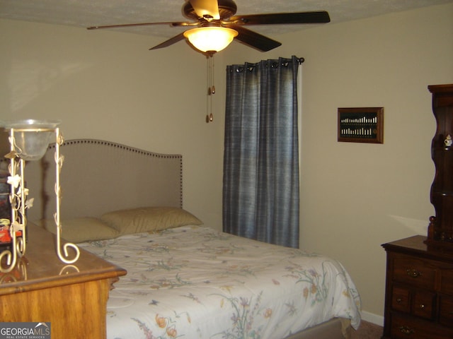 bedroom with ceiling fan and a textured ceiling