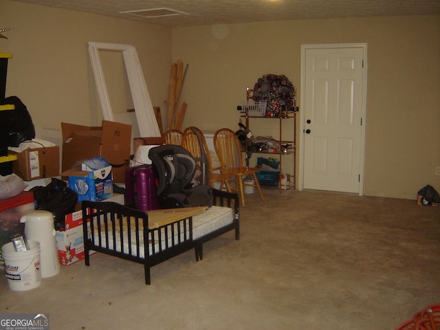 interior space with a textured ceiling and a crib