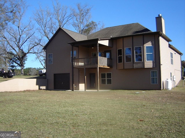 rear view of property with a balcony and a yard