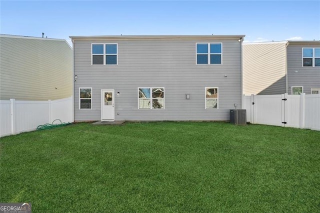 back of house featuring a yard and central AC