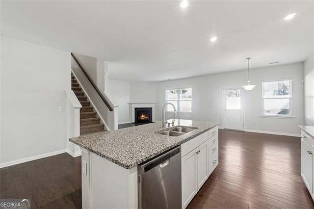 kitchen featuring stainless steel dishwasher, dark wood-type flooring, sink, decorative light fixtures, and white cabinetry