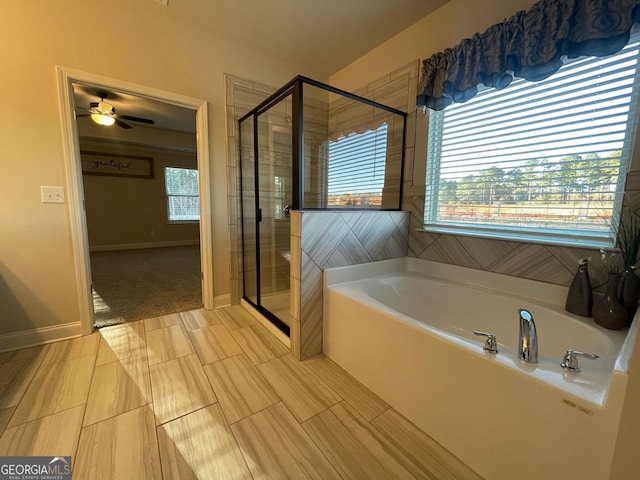 bathroom with plus walk in shower, ceiling fan, and a healthy amount of sunlight