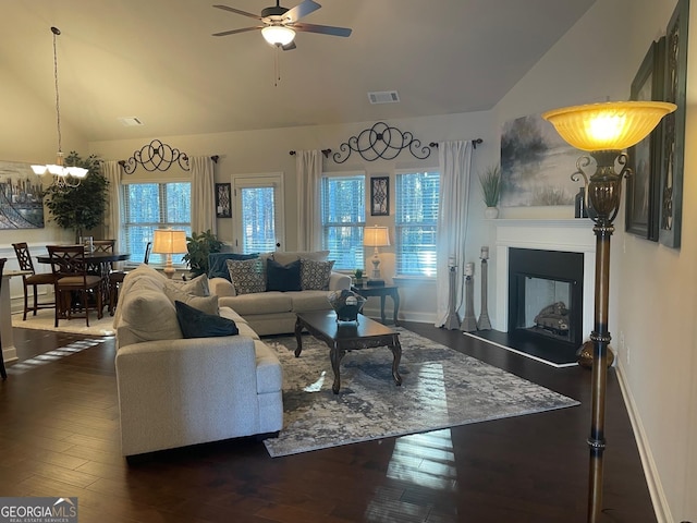 living room featuring dark hardwood / wood-style floors, lofted ceiling, and ceiling fan with notable chandelier