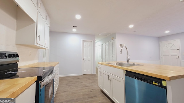 kitchen with wooden counters, stainless steel appliances, white cabinetry, and sink