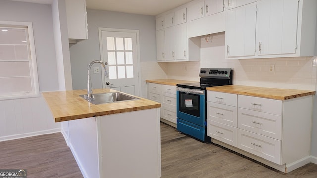 kitchen featuring white cabinetry, electric stove, sink, and wooden counters