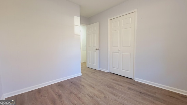 unfurnished bedroom with a closet and light hardwood / wood-style floors