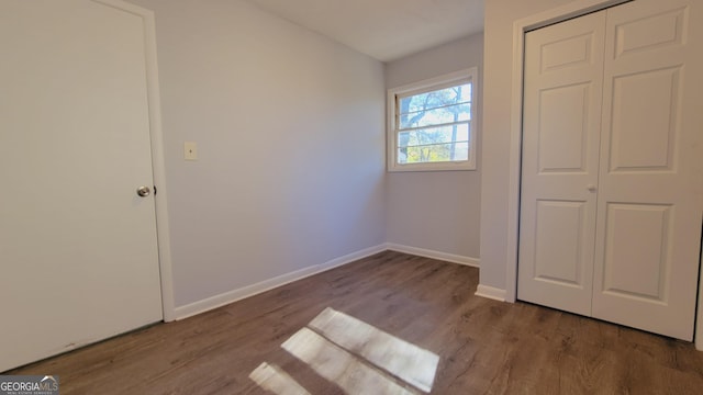 unfurnished bedroom featuring hardwood / wood-style floors and a closet