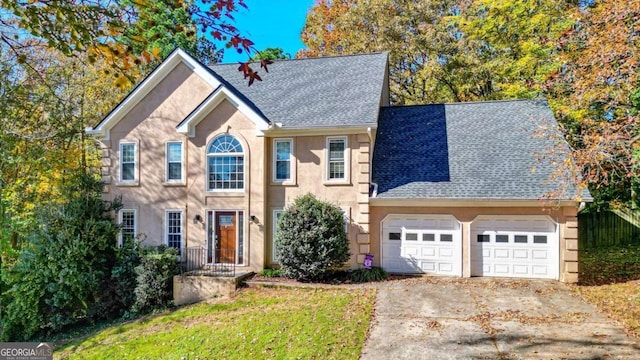 colonial house featuring stucco siding, an attached garage, driveway, and a shingled roof