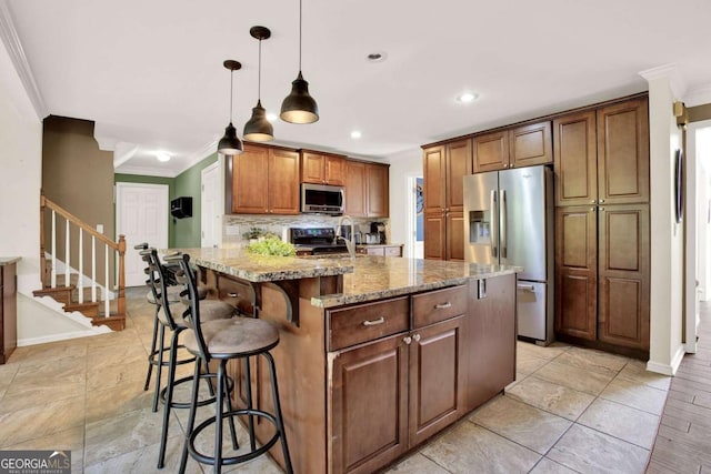 kitchen featuring crown molding, a kitchen breakfast bar, light stone counters, and appliances with stainless steel finishes