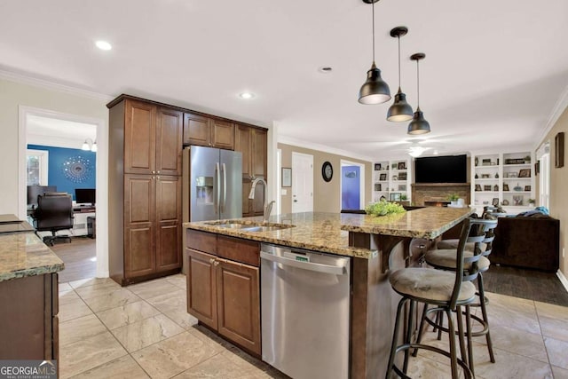 kitchen featuring crown molding, light stone countertops, open floor plan, appliances with stainless steel finishes, and a sink