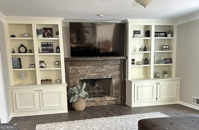 living area with a stone fireplace, baseboards, dark wood-type flooring, and visible vents