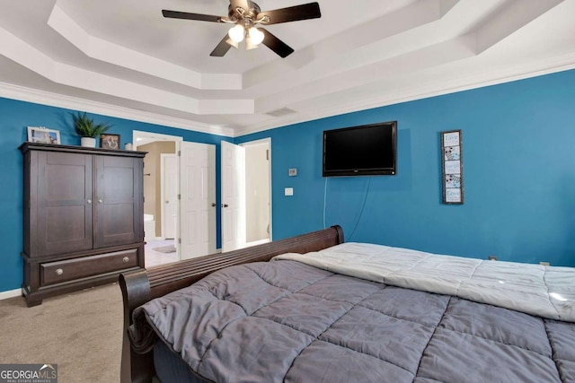 carpeted bedroom featuring baseboards, a raised ceiling, and ceiling fan