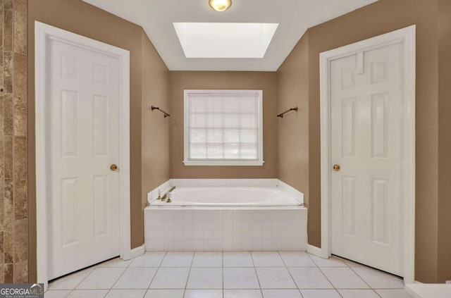 full bathroom with tile patterned floors, a skylight, and a garden tub