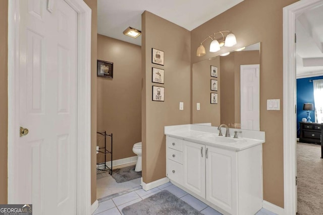 bathroom with tile patterned flooring, toilet, vanity, and baseboards