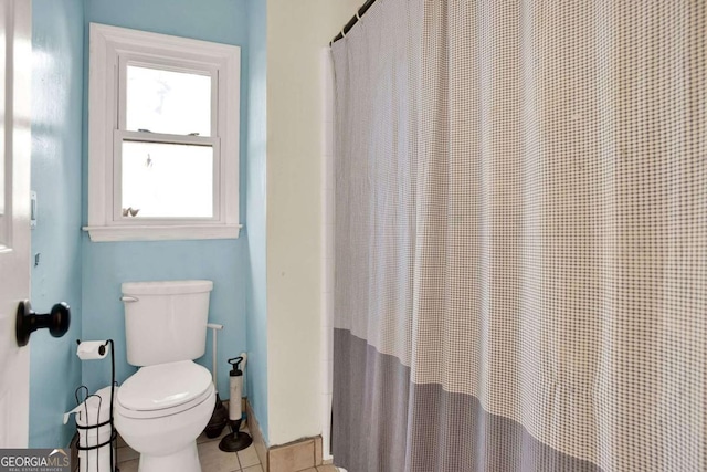 bathroom with tile patterned floors, toilet, and a shower with curtain