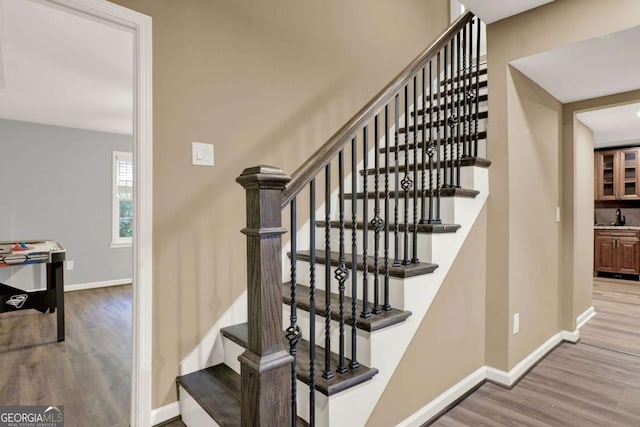 stairs with wood finished floors and baseboards