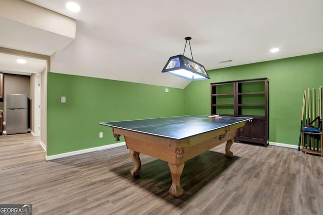 rec room with visible vents, light wood-style floors, baseboards, and vaulted ceiling