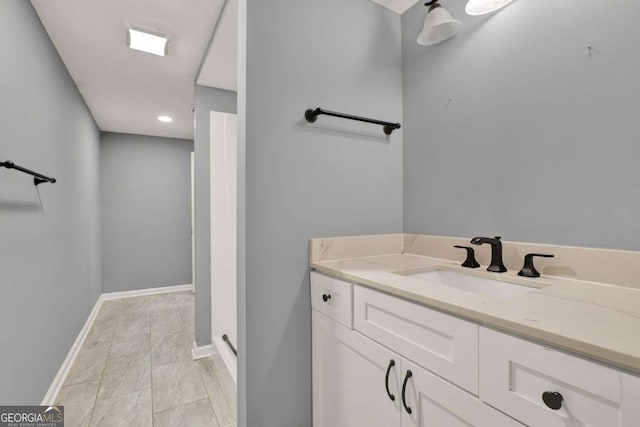 bathroom with vanity, a shower, and baseboards