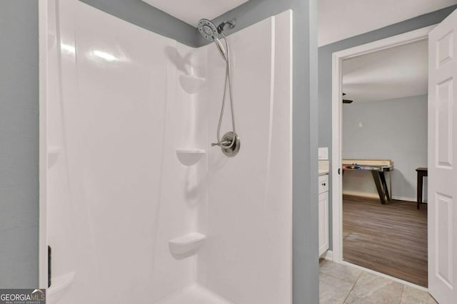 full bathroom featuring a shower, baseboards, and tile patterned flooring