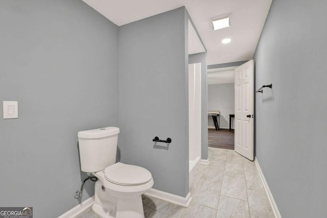 bathroom with baseboards and toilet