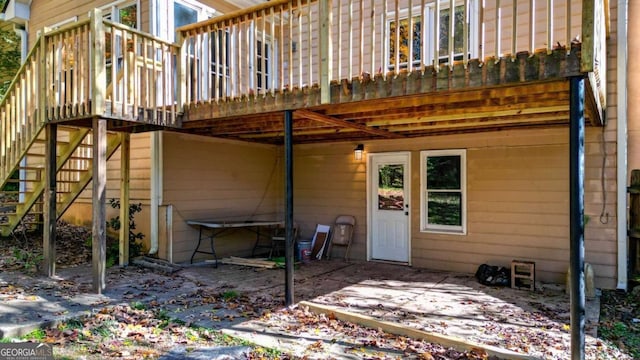 rear view of house with stairway and a wooden deck