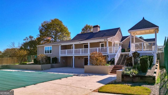 rear view of property with a patio, stairs, fence, a fenced in pool, and a chimney