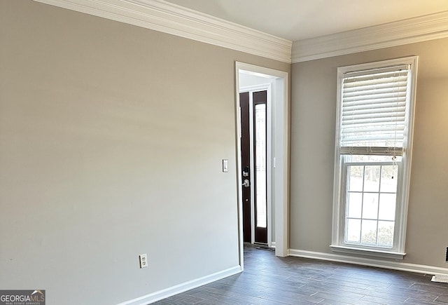 spare room featuring baseboards, ornamental molding, and dark wood-style flooring