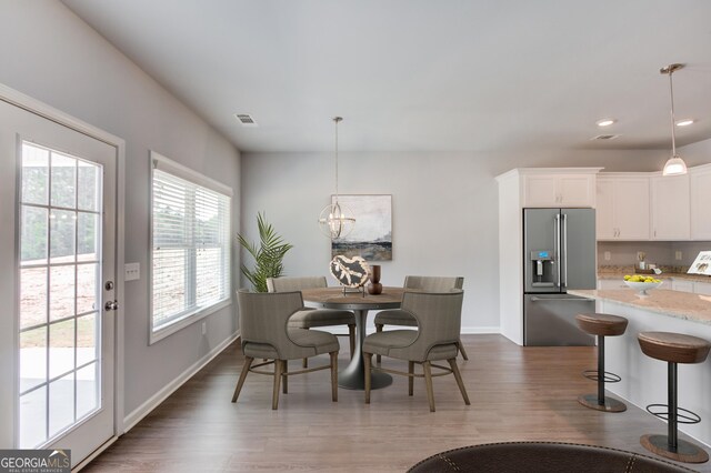 dining area with a notable chandelier, dark wood-type flooring, and a wealth of natural light