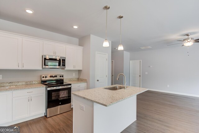 kitchen with white cabinetry, sink, hanging light fixtures, a center island with sink, and appliances with stainless steel finishes