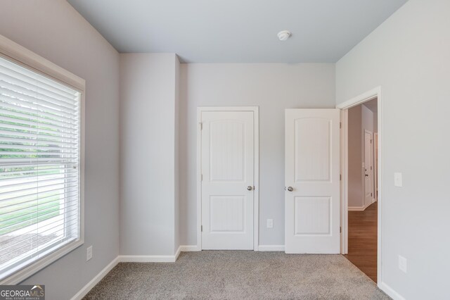 unfurnished bedroom with carpet floors and multiple windows