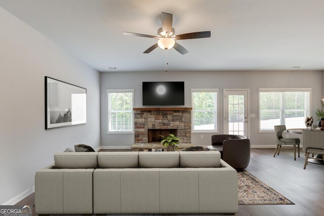 living room featuring ceiling fan, wood-type flooring, and a fireplace