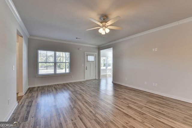 spare room featuring hardwood / wood-style flooring, ceiling fan, and crown molding